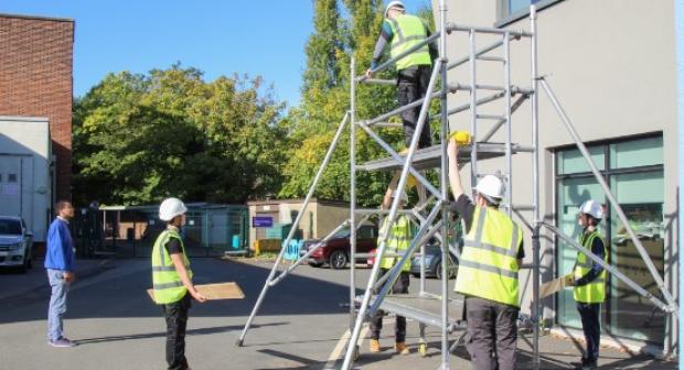 Electrical students put up scaffolding towers in practical session