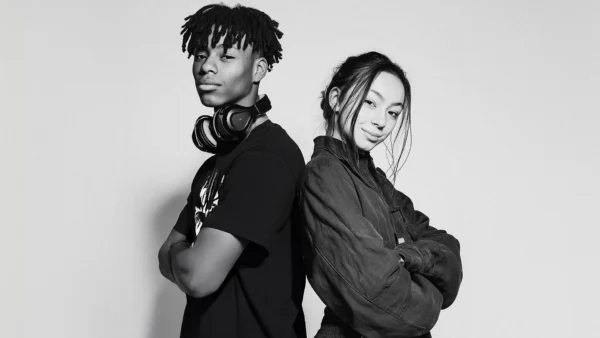 A male and a female student standing back to back