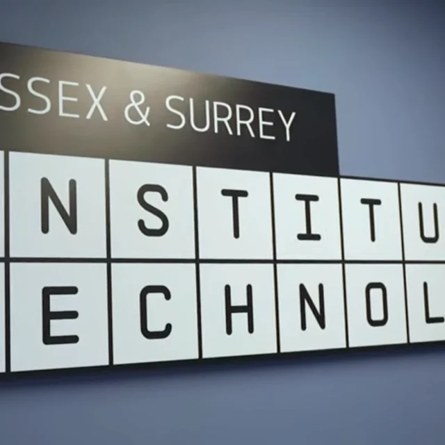 A wall-mounted sign displaying the words “Sussex & Surrey Institute of Technology” in a black and white block-style grid.