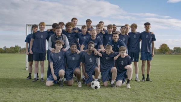 Student Football Academy Team posing on a football pitch in front of the goal