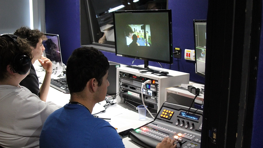 Students using a vision mixer and monitors to control video production in a gallery.