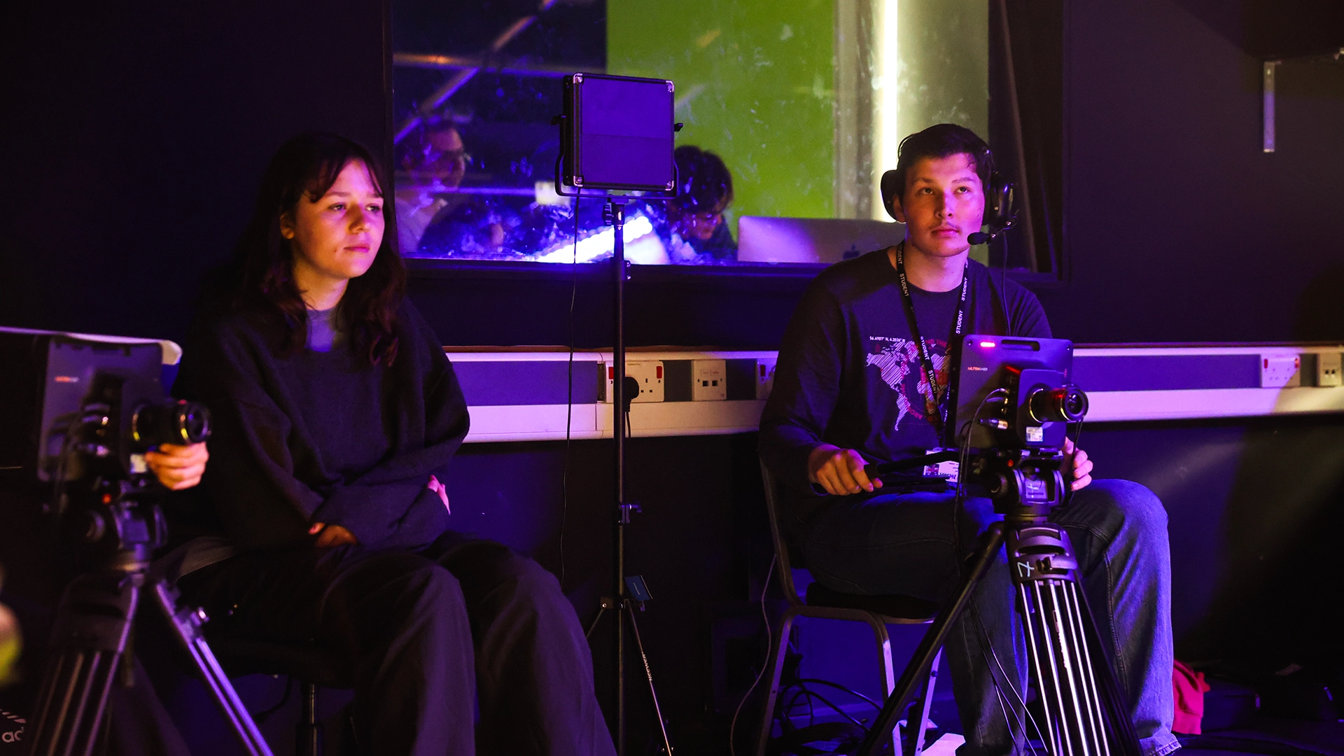 Students seated with cameras and lighting equipment in a studio environment.