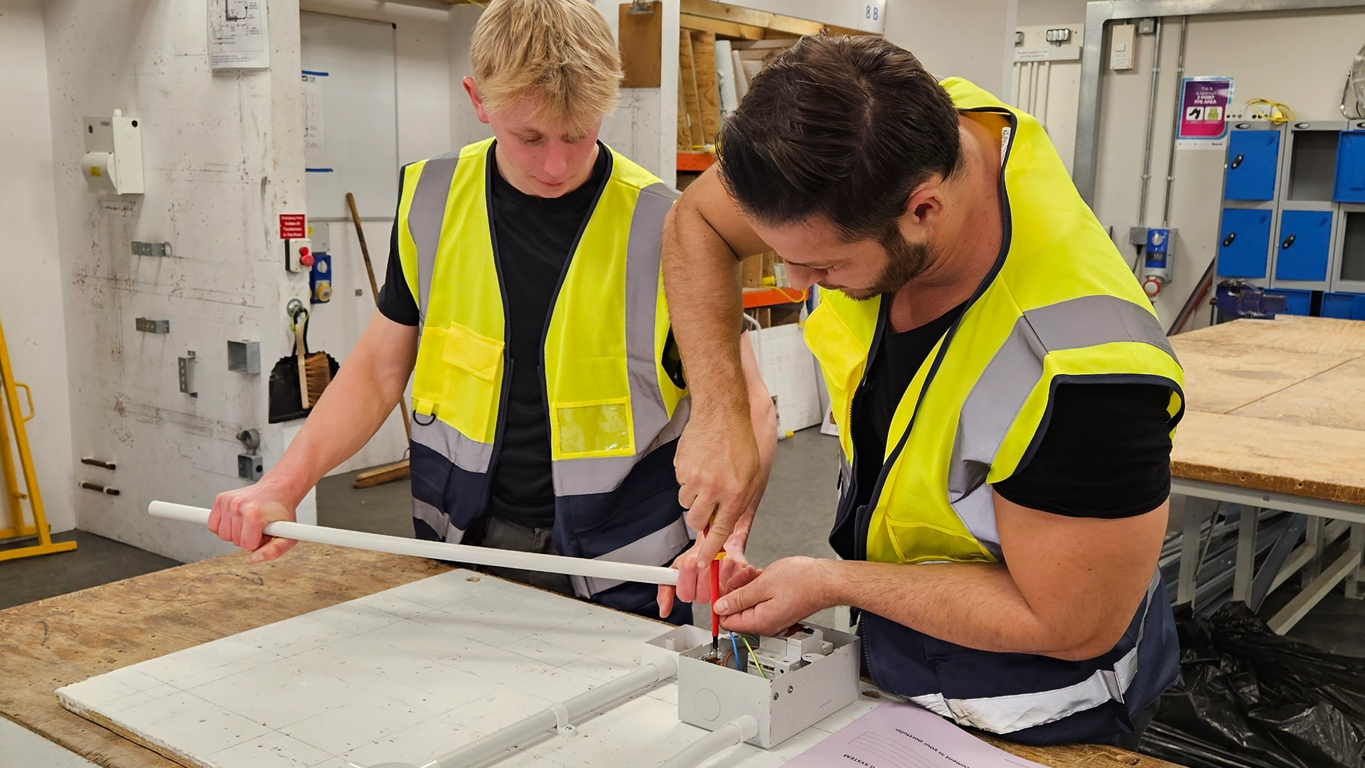 Learner and tutor wiring an electrical box during practical training