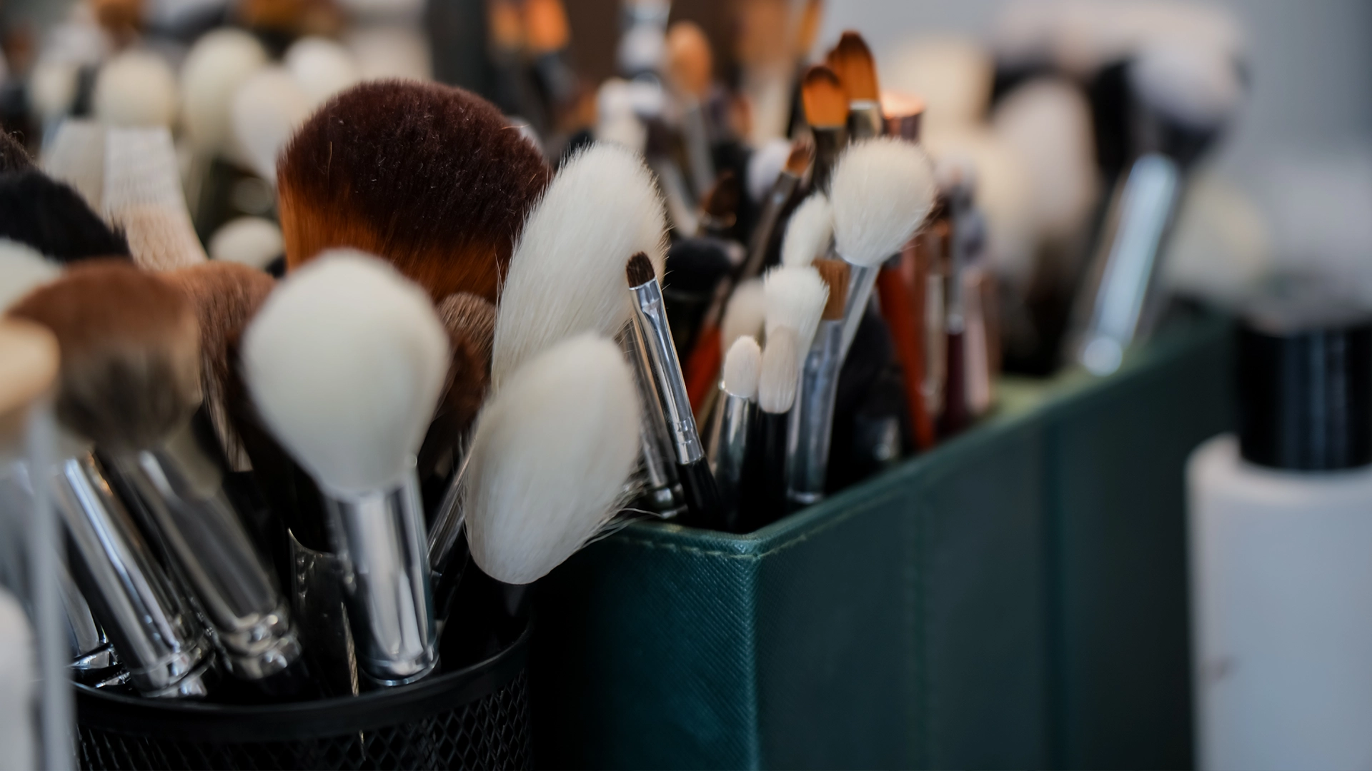 Close-up of make-up brushes in a holder on a salon workstation.