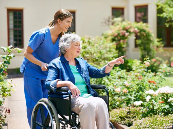 Photo of a resident and a care assistant outside in a retirement home garden.
