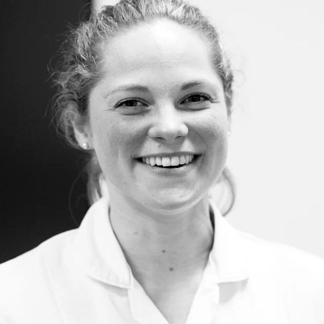 Portrait of a person in a white medical coat.