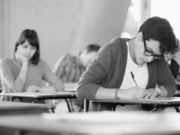 Students seated at desks completing an exam in a classroom setting