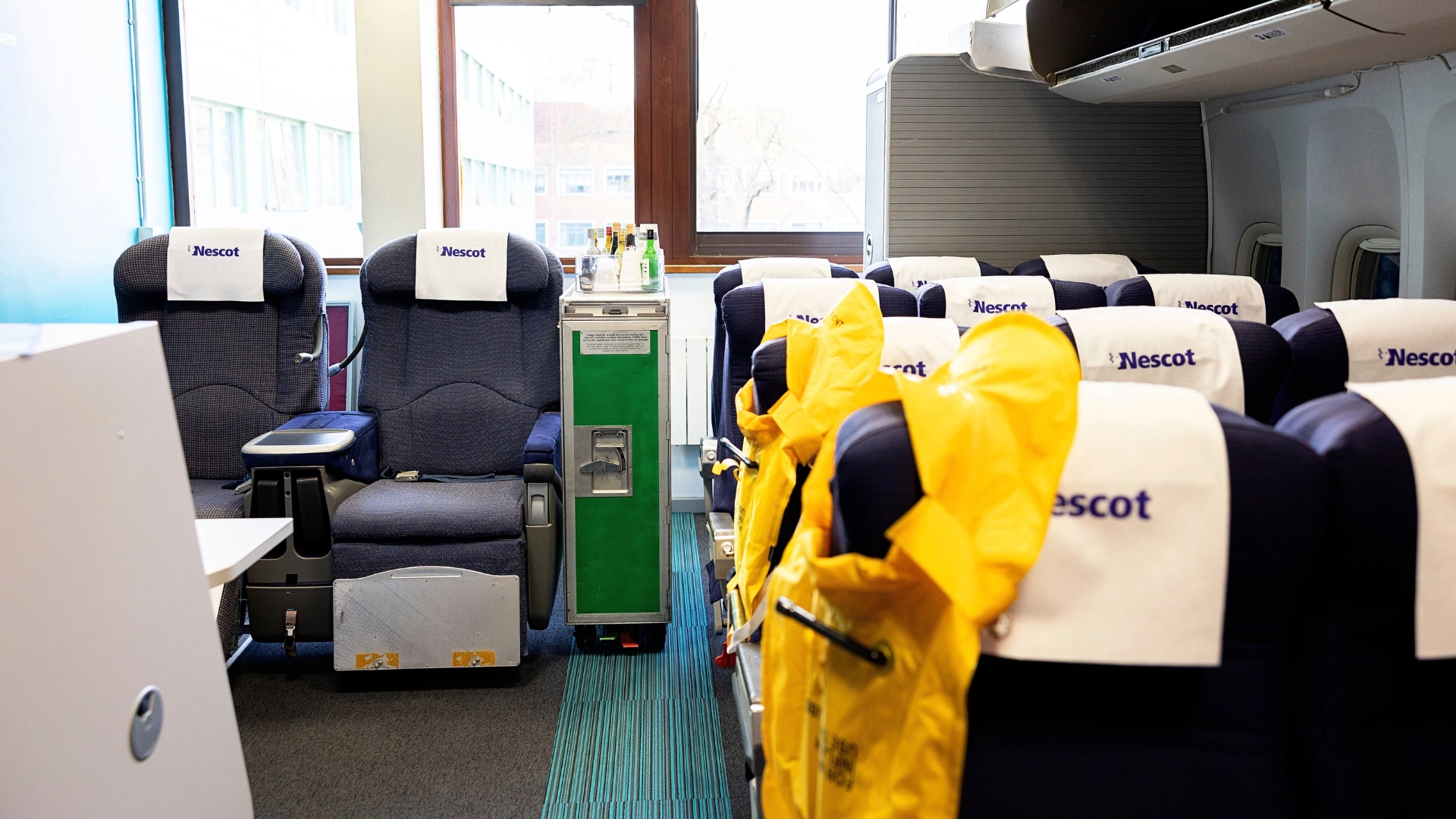 Travel Cabin Room with Nescot logo on the headrests and life jackets on the seats.