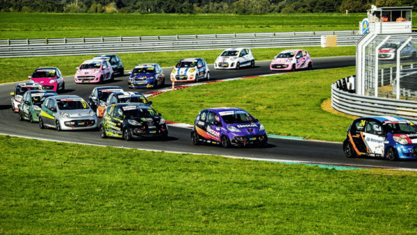 The Nescot Motorsport race car competes in a tightly packed group at Snetterton Circuit, battling for position during a Student Motorsport race