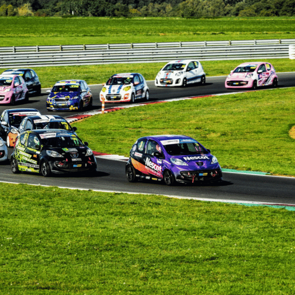 The Nescot Motorsport race car competes in a tightly packed group at Snetterton Circuit, battling for position during a Student Motorsport race