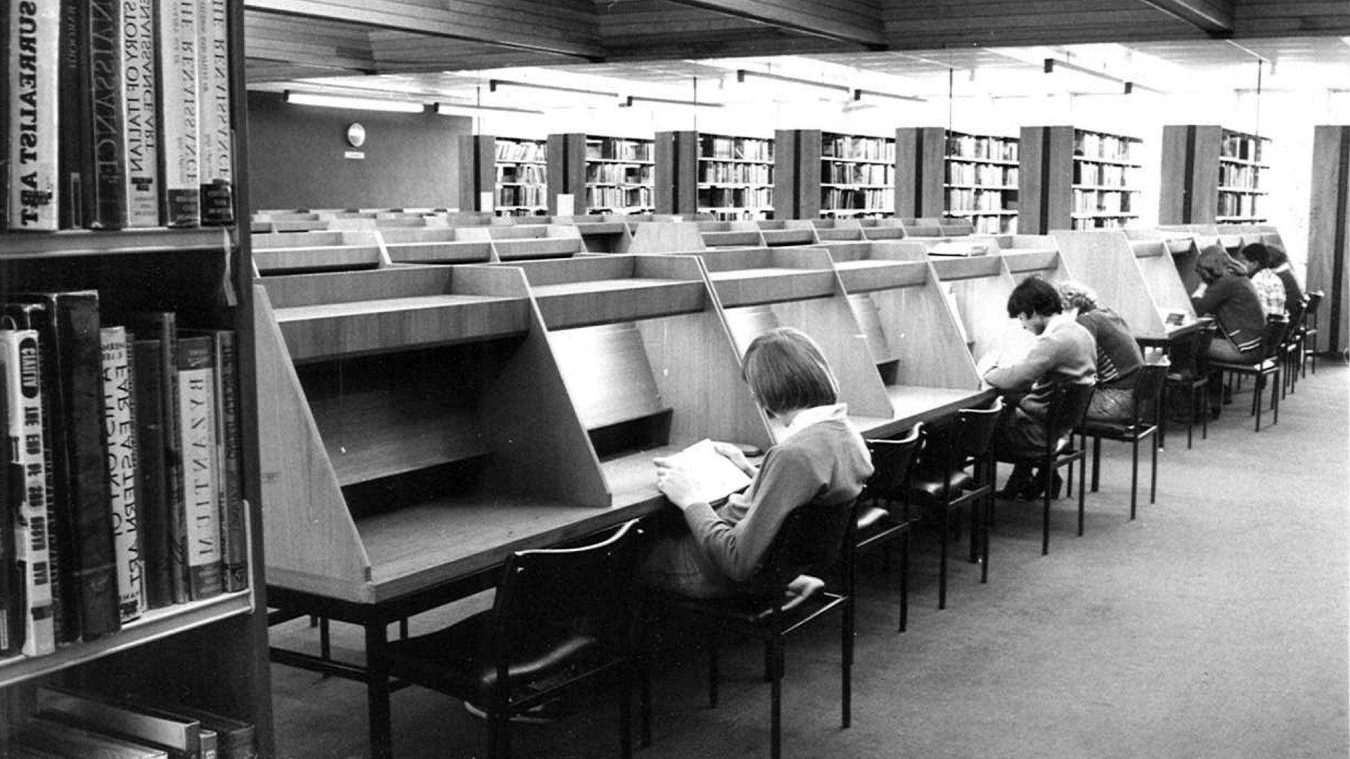 Historic black and white photo of the Learning Resource Centre showing students studying at individual wooden booths.