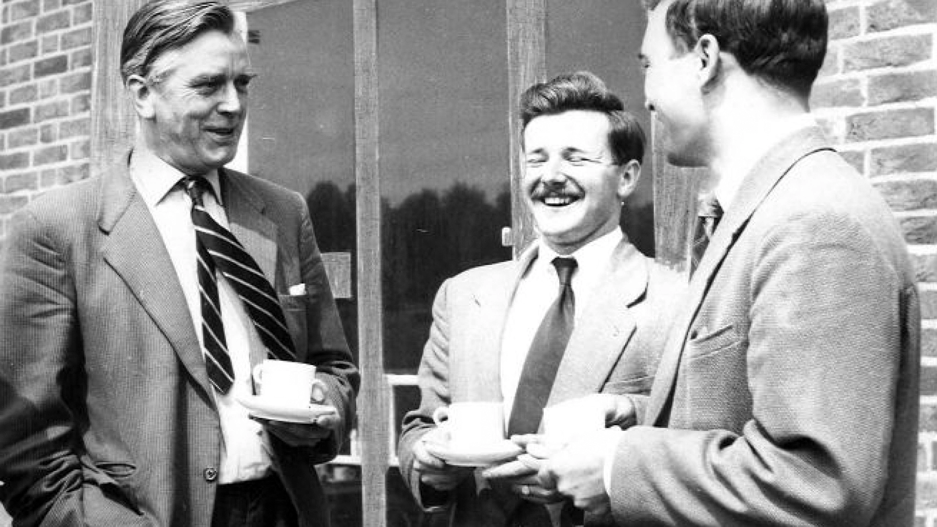 Historic black and white photo showing first principal Thomas Buchanan laughing with two other members of staff