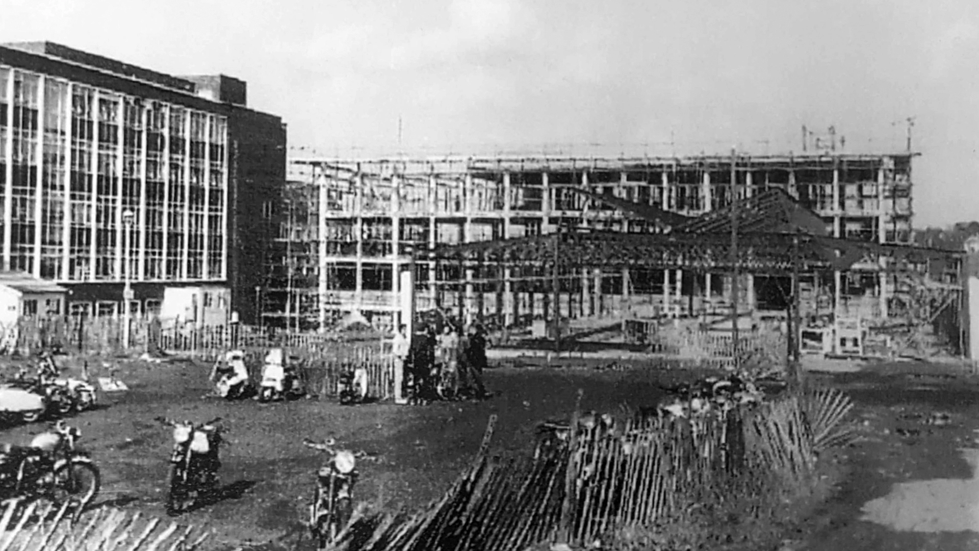 Historic black and white photo showing the progress of construction of a new four-storey extension in 1964